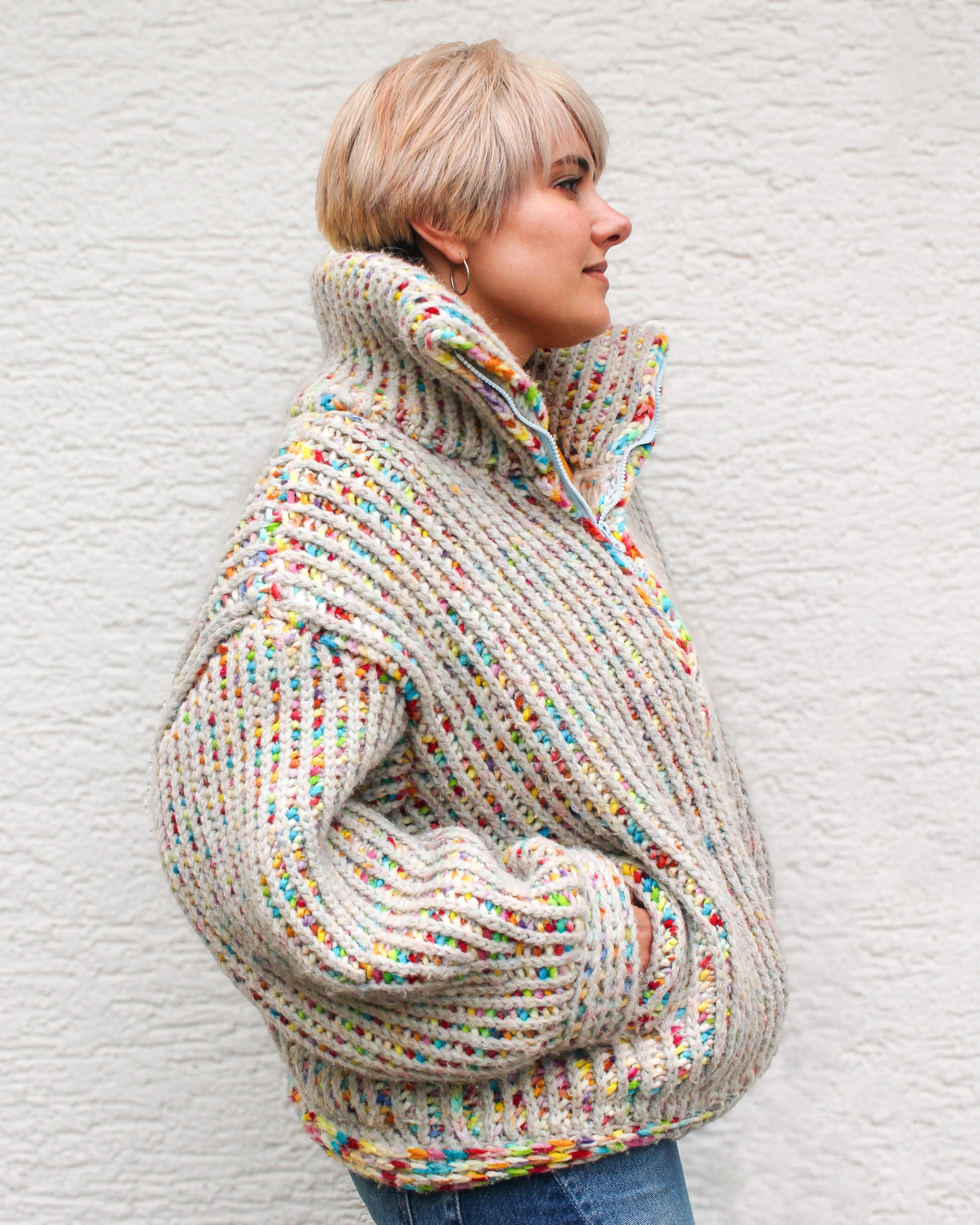 Pattern designer wearing a size MEDIUM Brioche Crochet Pullover in the fruity pebbles colorway, side view showing the drop-shoulder silhouette and brioche stitch texture.