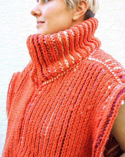 Brioche Crochet Vest — lifestyle front view in Sherbet colorway on size medium designer, fully zipped chunky brioche stand-collar at sun-dappled studio wall, oversized sleeveless statement piece.